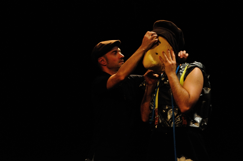 photo of the Larven show - Patrick Forian adjusts a mask of a actor